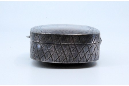 Caixa de comprimidos em prata com gravados envolvendo cartela e tampa basculante